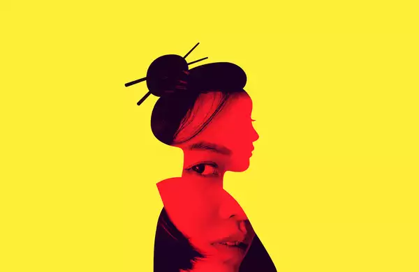 A silhouette of a woman in side profile wearing her hair in a bun with Juda sticks on a bright yellow background.