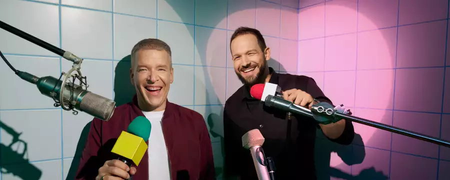 Paczes & Lotek smiling and holding microphones