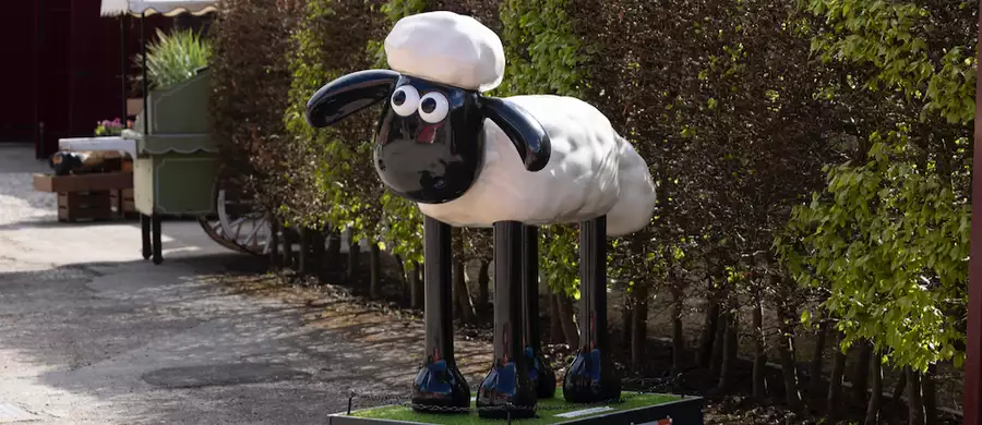 A Shaun the Sheep sculpture outside in a garden