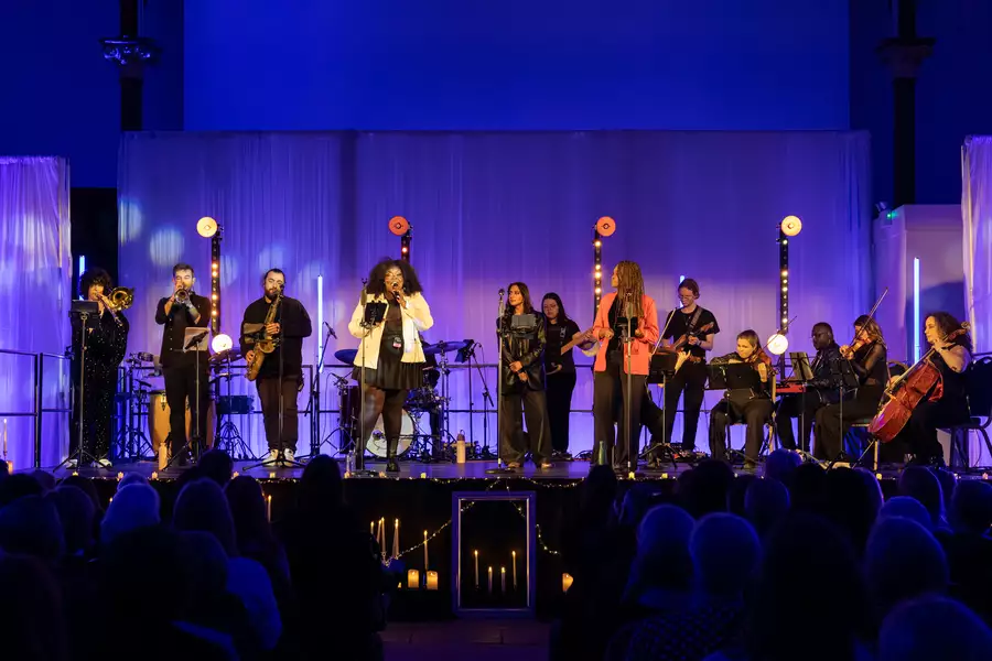 The Untold Orchestra perform on stage bathed in purple lighting