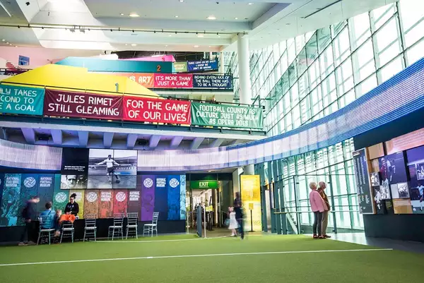 The atrium of the National Football Museum. Football banners and a handful of people are visible.