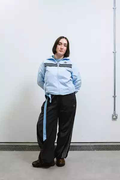 Lara Ptolomey wearing a light blue jacket and black trousers
