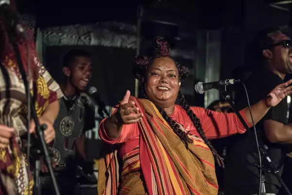 Members of Votia performing on stage and smiling