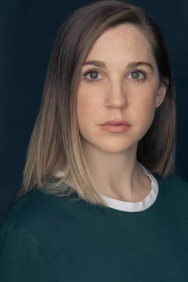 Susie Barrett in a teal top against a black background