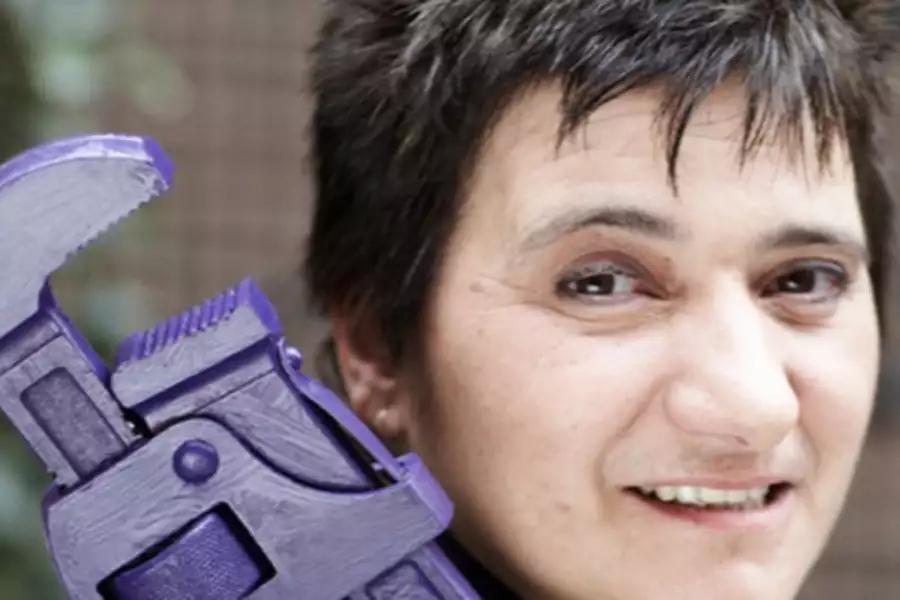 Hattie Hasan posing with a plumbing instrument