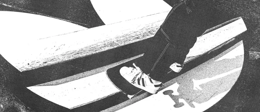 Black and white image of someone skateboarding on an Adidas skate ramp wearing Adidas trainers