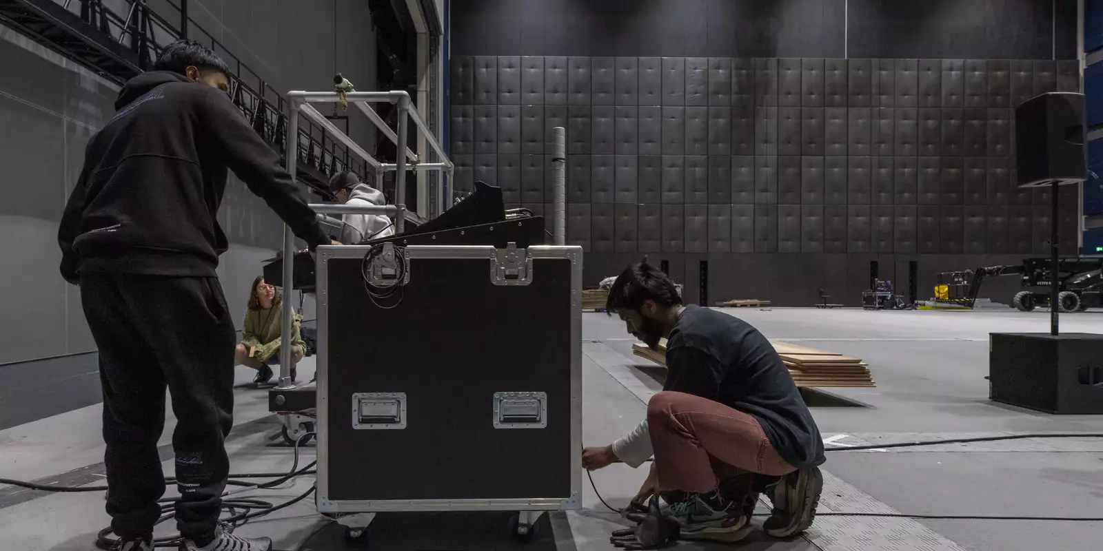 People plugging in lighting equipment in a large warehouse