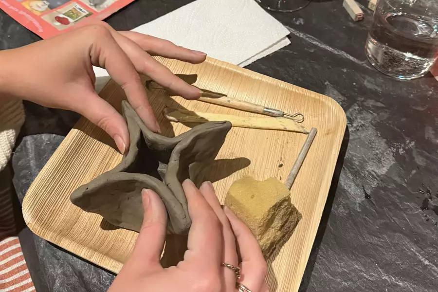 A person handling a star clay sculpture