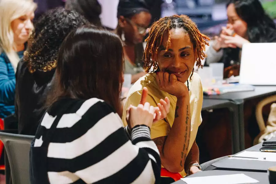 Two people sat at a table in discussion, with a piece of paper in front of them