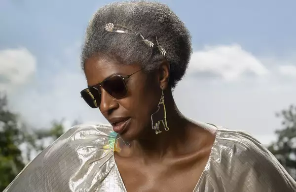DJ Paulette wears a silver dress and sunglasses