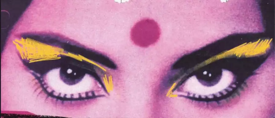 A close-up of a woman's eyes with bold yellow makeup and a red dot on her forehead