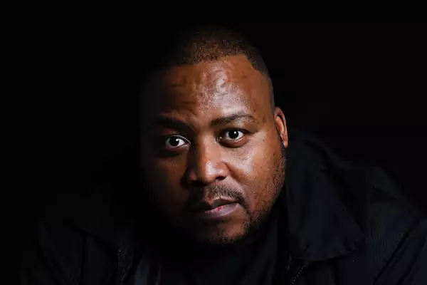 Headshot of Stogie T on a black background