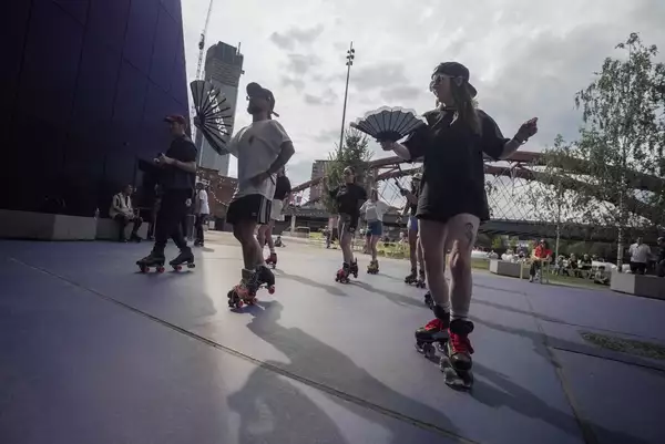 People roller skating with fans outside Aviva Studios in the sunshine