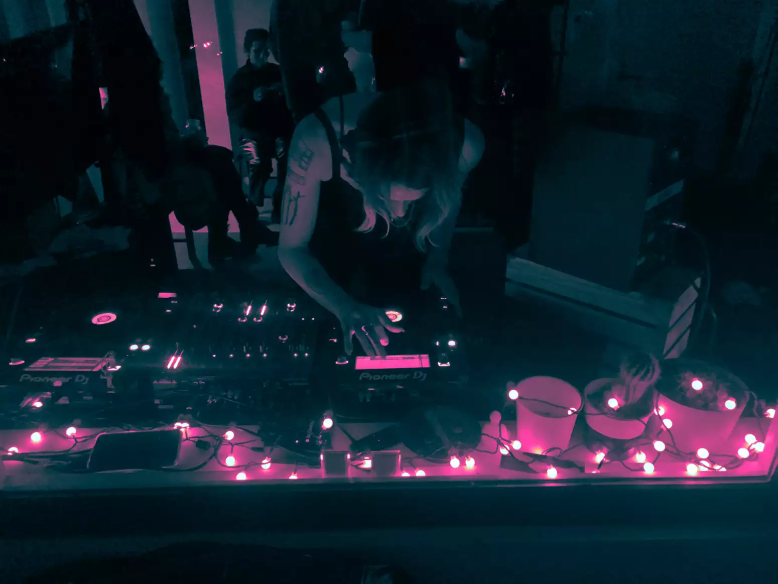 A person DJs surround by fairy lights
