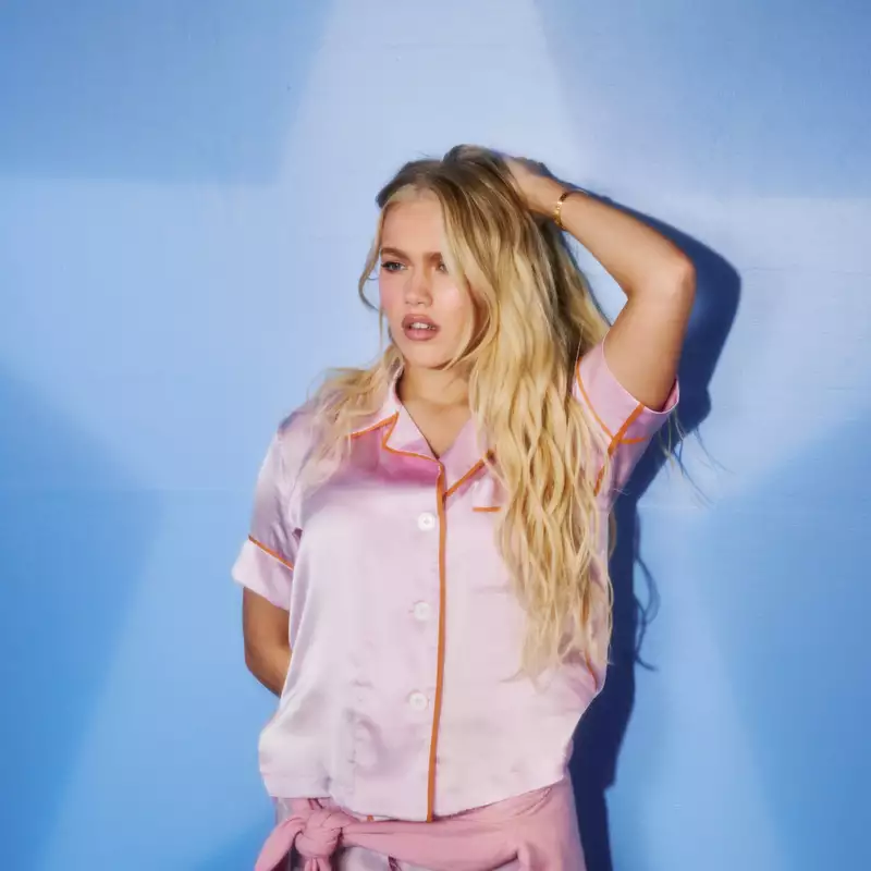 Freya Skye wearing pink on a light blue background