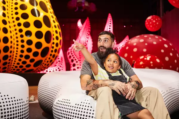 A father and daughter enjoy Yayoi Kusama: You, Me and the Balloons at Aviva Studios