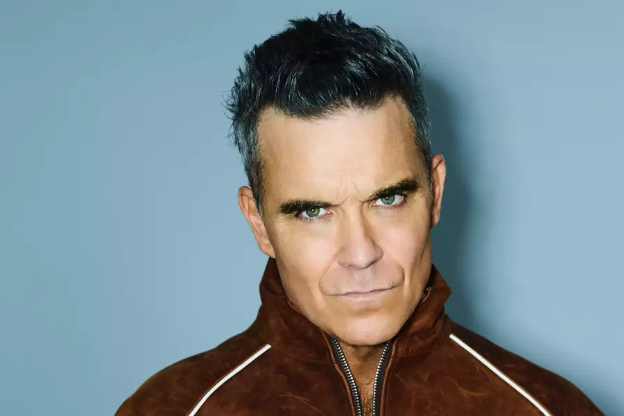 Robbie Williams on a light blue background