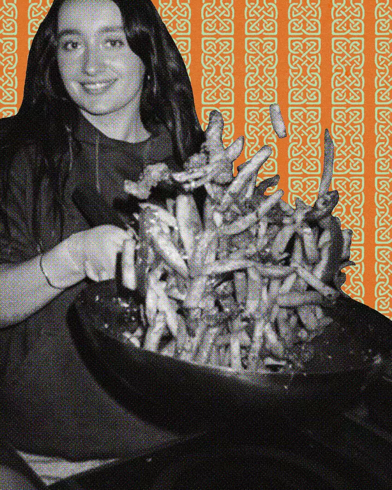 Person holding a large wok against a patterned orange background.