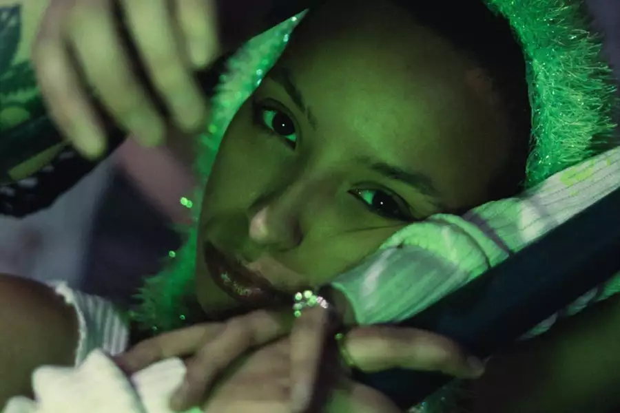 A green light shines on singer Karis Jade