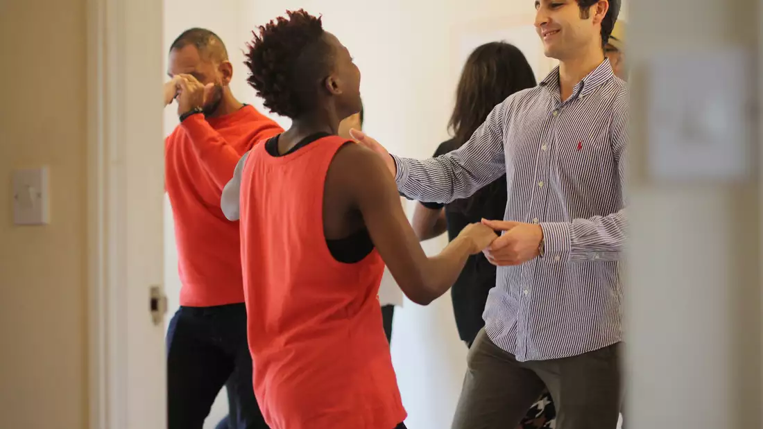Two people dancing inside a living room at a micro-festival