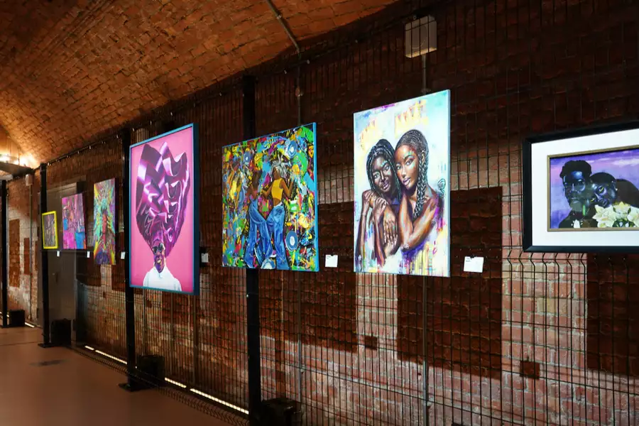 A photograph of the exhibition in the Sim tunnel, showing paintings hung on the wall of a tunnel