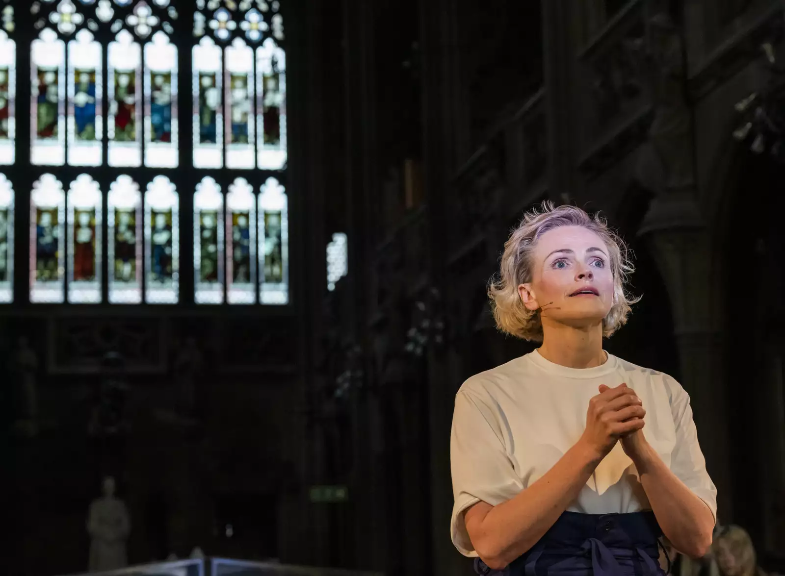Photo of Maxine Peake performing in front of a stained glass window