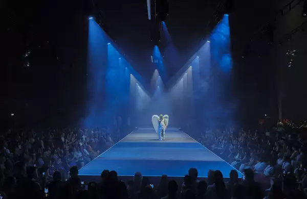 A performer on the runway with a huge crowd in the Warehouse during House of MCR