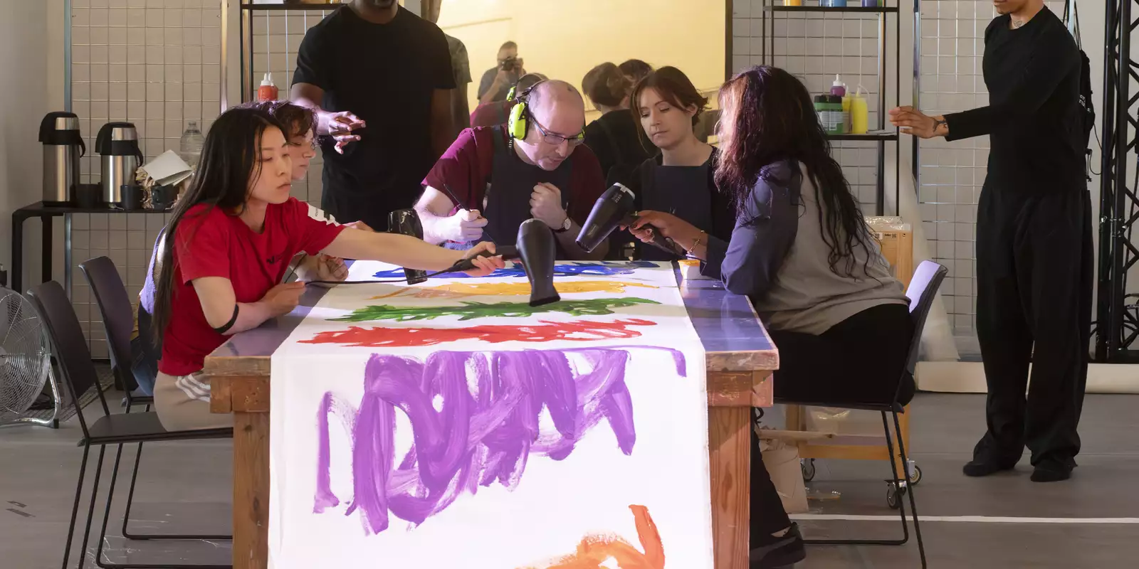 Michael Beard working on an artwork with a group of people during his residency at MIF23