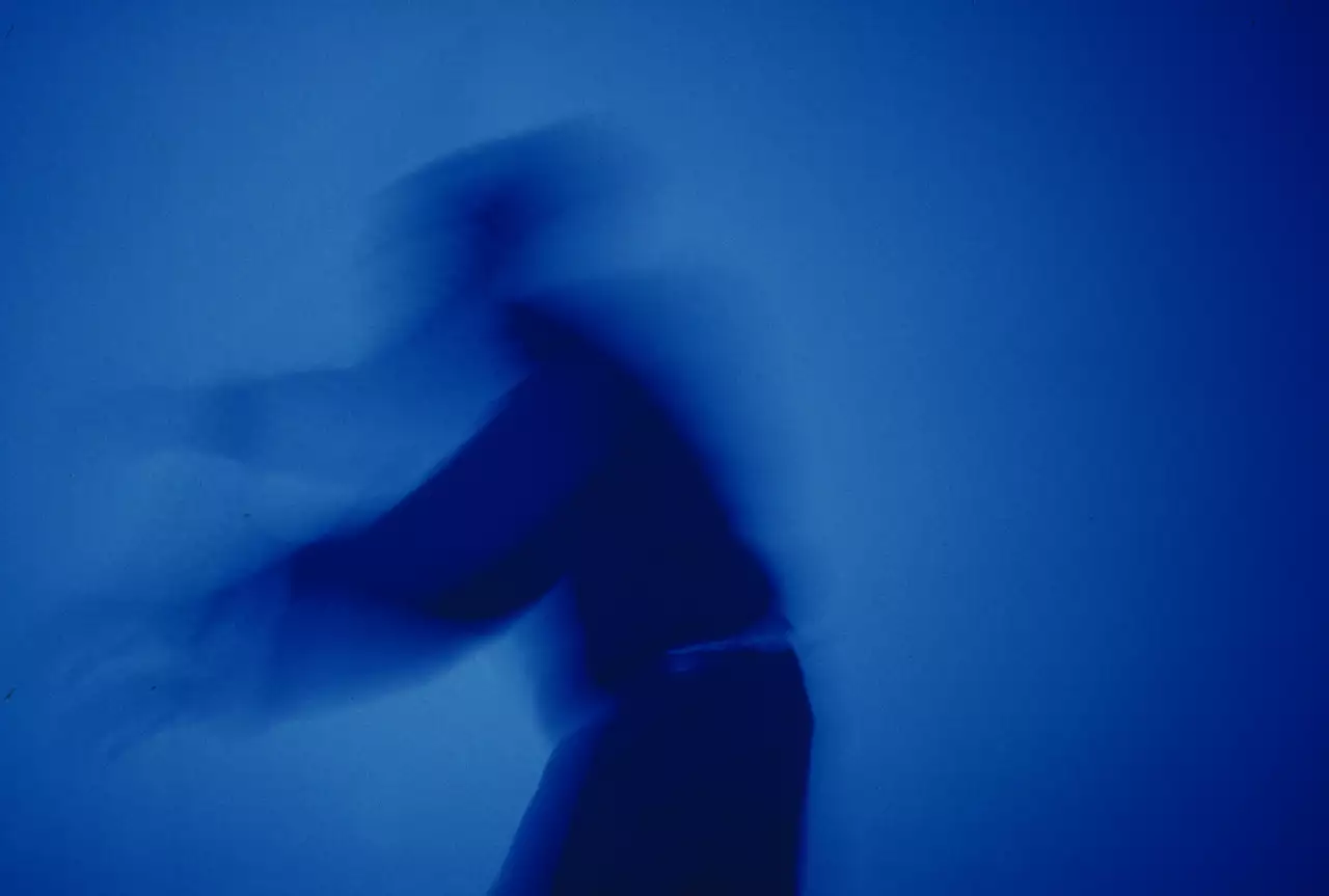 Still from Blue Now, showing the silhouette of a man on a blue background