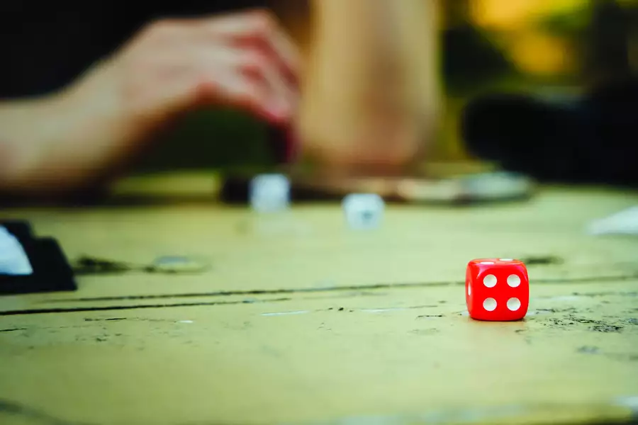 A person throwing a dice on a board game