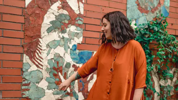 Photograph of a person pointing at street art on a wall