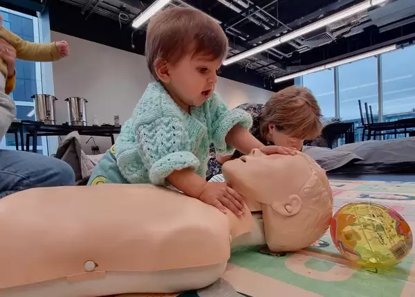 A child touching a first aid dummy