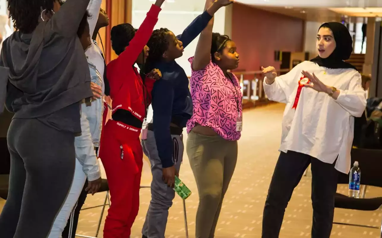 A group of young people engage with a facilitator.