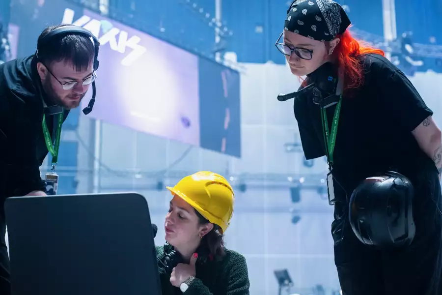 Three people working behind the scenes in the Warehouse. One is wearing a yellow hardhat.