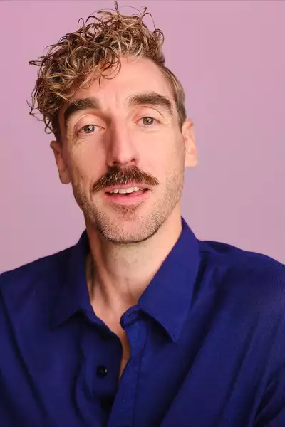 Headshot of Simon Palmer on a pink background