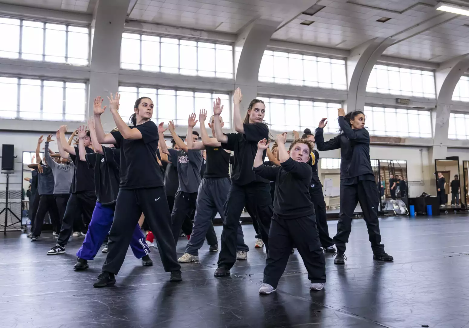 Dancers for Free Your Mind with hands raised to clap in rehearsals