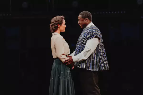 Two actors on stage during Liberation holding each other