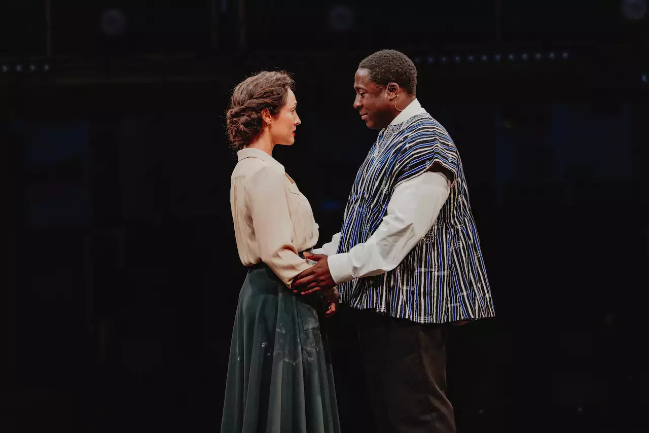 Two actors on stage during Liberation holding each other
