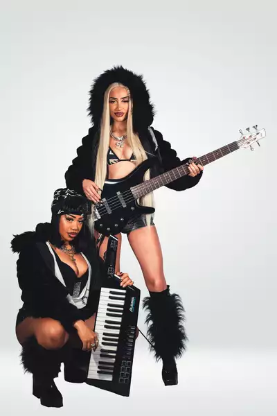 KULTURESS wearing black outfits, holding a a guitar and keyboard on a white background