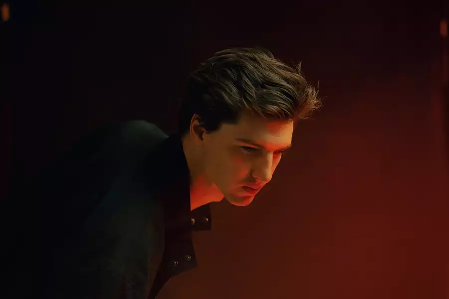 Luke Mombrea wearing a black shirt on a red background