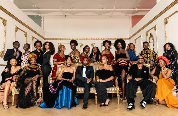 Group photo of the performers at Black Creative Trailblazers, wearing cultural attire and black tie in a ball room