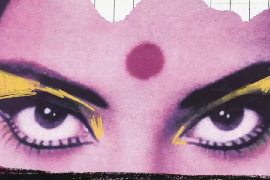A close-up of a woman's eyes with bold yellow makeup and a red dot on her forehead