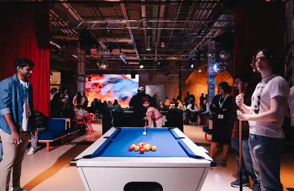 Three people playing pool in the busy Social