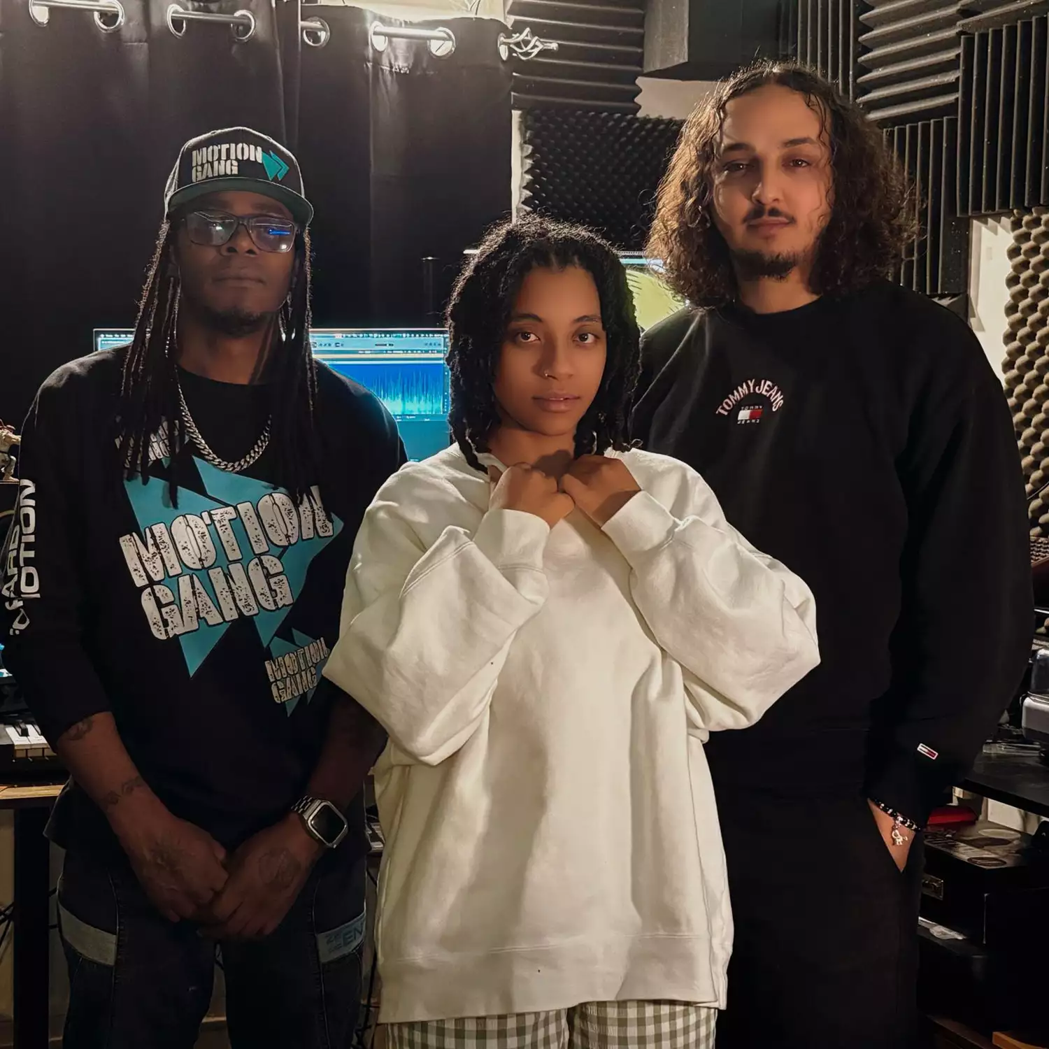 Three members of Raise the Bar and Spynal Records smiling in a recording studio