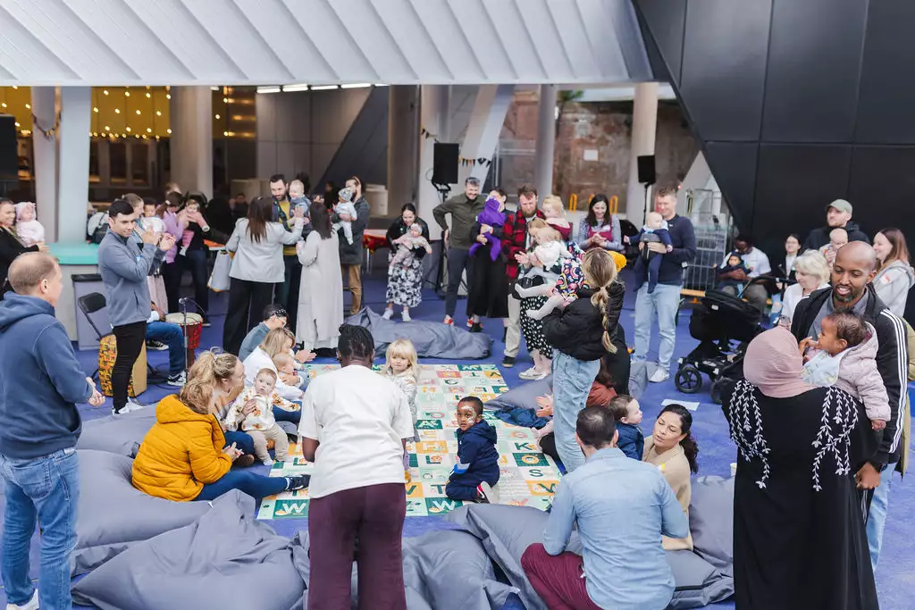 First breath families stood outside Aviva Studios talking, laughing and playing