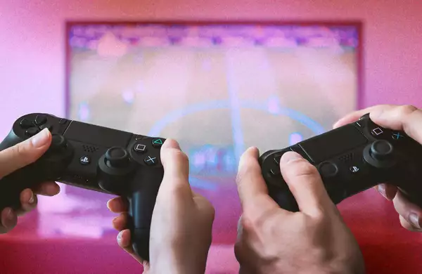 Two consoles in front of a glittery pink screen