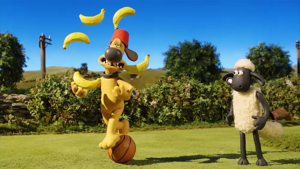 Still from Shaun the Sheep showing Shaun watching Bitzer juggling with bananas