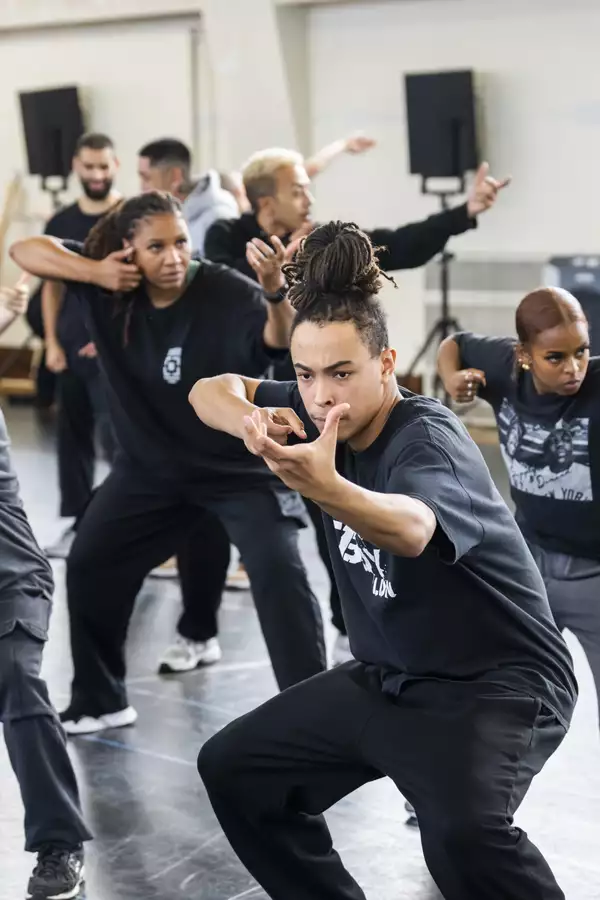 Dancers for Free Your Mind miming a handheld gun in rehearsals
