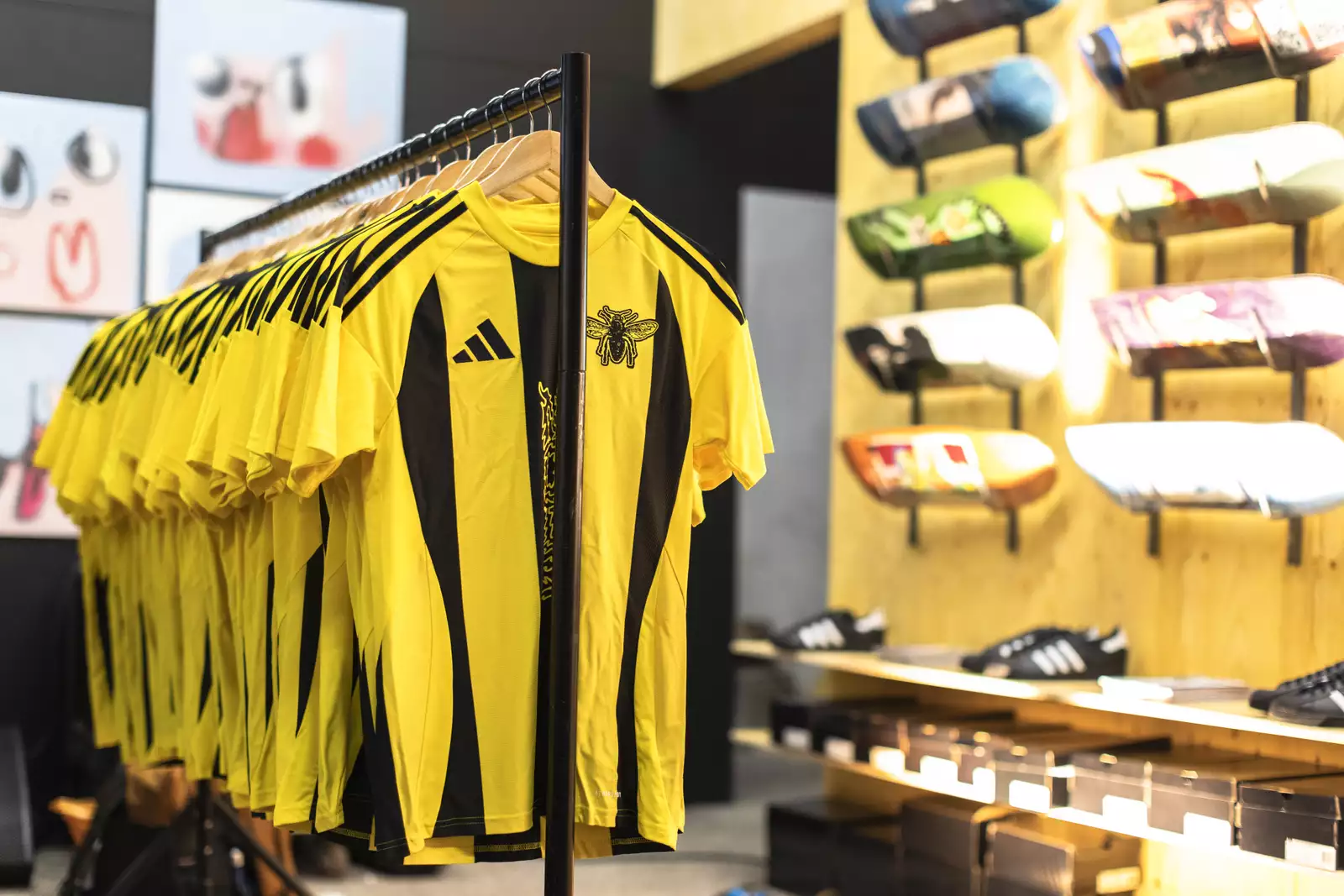 A clothes rail of yellow and black striped football shirts inside the Build Manchester pop-up skate shop.