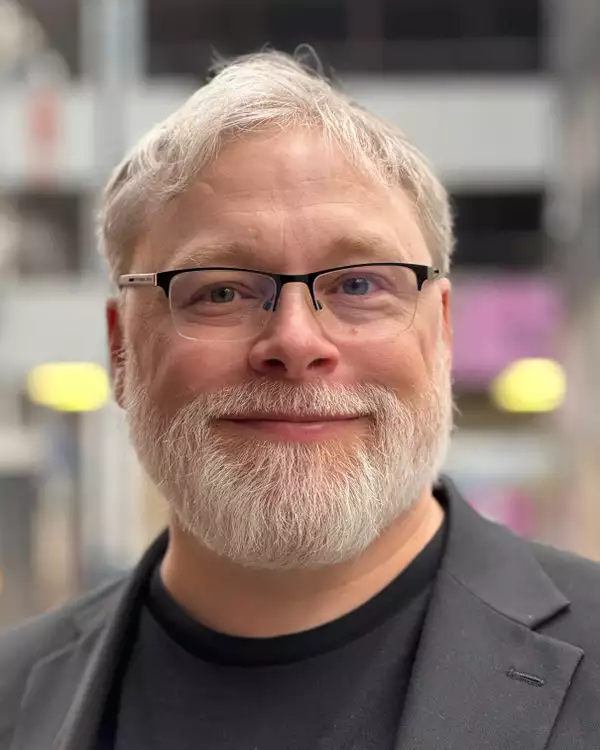 Headshot of Gareth Fry smiling wearing a suit jacket